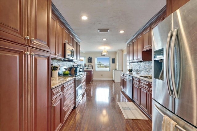 kitchen with baseboards, light stone countertops, dark wood finished floors, decorative backsplash, and stainless steel appliances