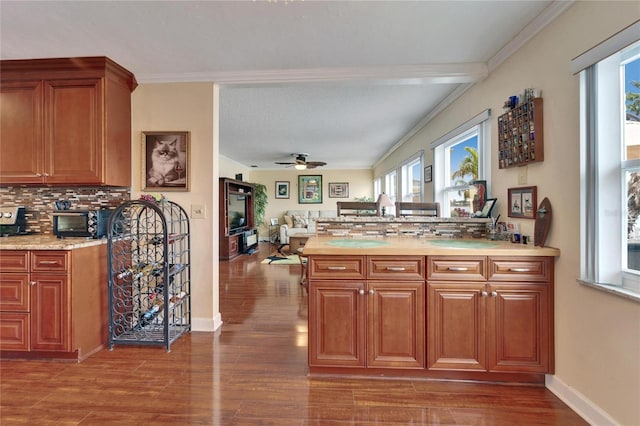 kitchen featuring brown cabinetry, backsplash, light countertops, and wood finished floors