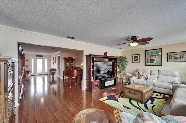 living room with wood finished floors, visible vents, and ornamental molding