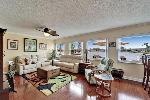 living room with hardwood / wood-style floors, ceiling fan, baseboards, and ornamental molding