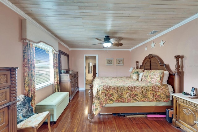 bedroom with visible vents, crown molding, and wood finished floors