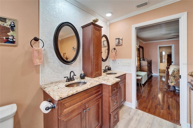 bathroom with visible vents, toilet, ensuite bathroom, wood finished floors, and crown molding