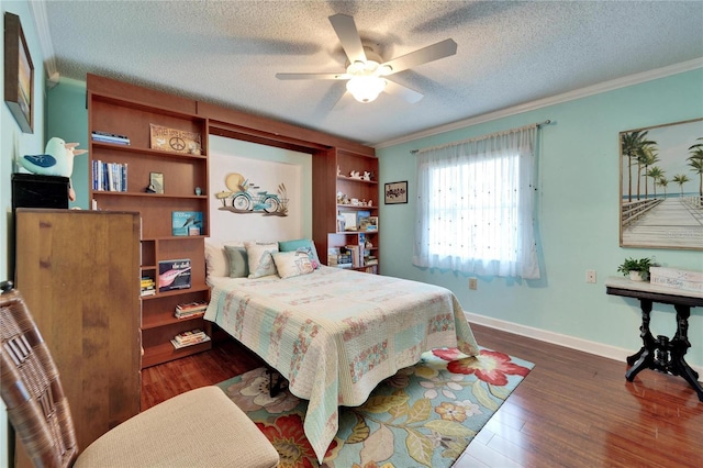 bedroom with ornamental molding, a textured ceiling, baseboards, and wood finished floors