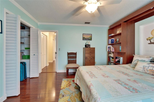 bedroom featuring visible vents, ornamental molding, a textured ceiling, and dark wood-style flooring