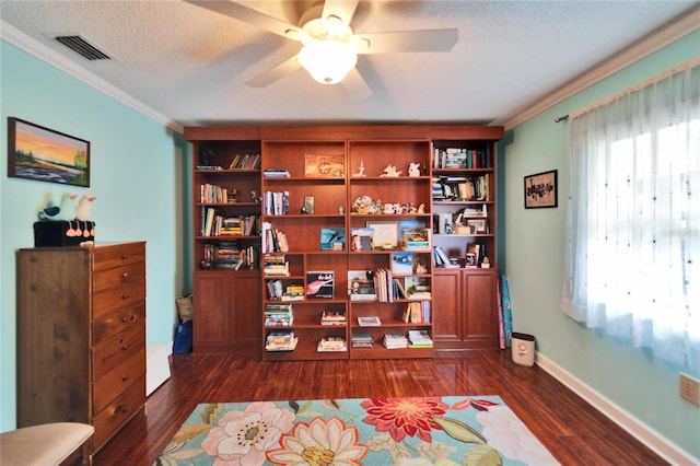 sitting room featuring dark wood-type flooring, ornamental molding, visible vents, and a textured ceiling