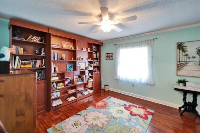 sitting room with dark wood finished floors, ornamental molding, baseboards, and a textured ceiling