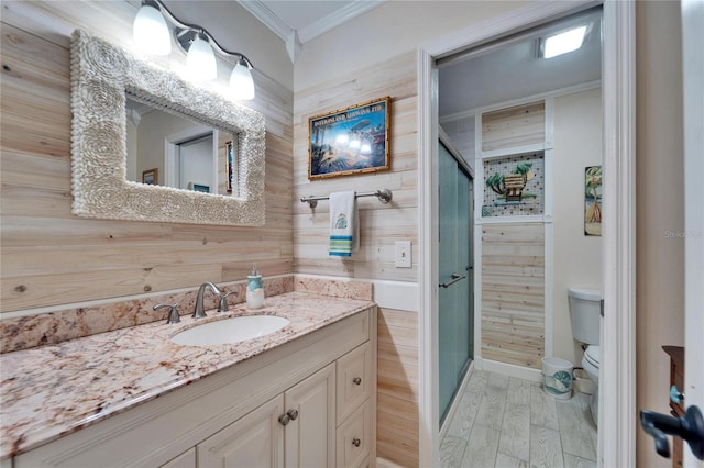 bathroom featuring vanity, wood finished floors, a shower stall, crown molding, and toilet