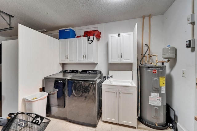 laundry area featuring a sink, electric water heater, a textured ceiling, washing machine and dryer, and cabinet space