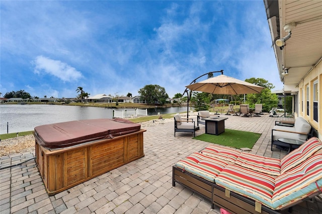 view of patio with outdoor lounge area, a water view, and a hot tub