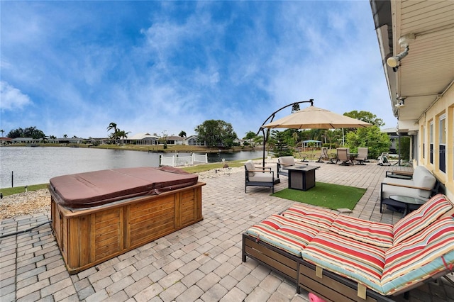 view of patio / terrace featuring an outdoor hangout area, a water view, and a hot tub