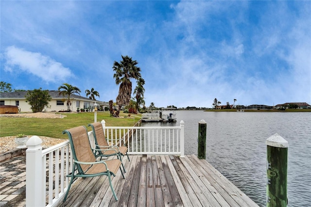 dock area with a water view and a lawn