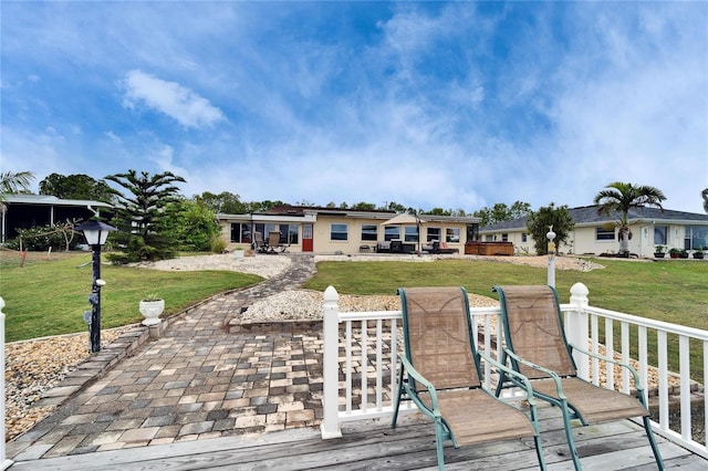 rear view of property featuring a patio and a yard