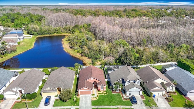 aerial view featuring a wooded view, a residential view, and a water view