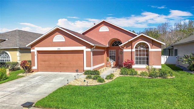 single story home with stucco siding, fence, concrete driveway, an attached garage, and a front yard