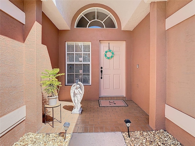 entrance to property featuring stucco siding