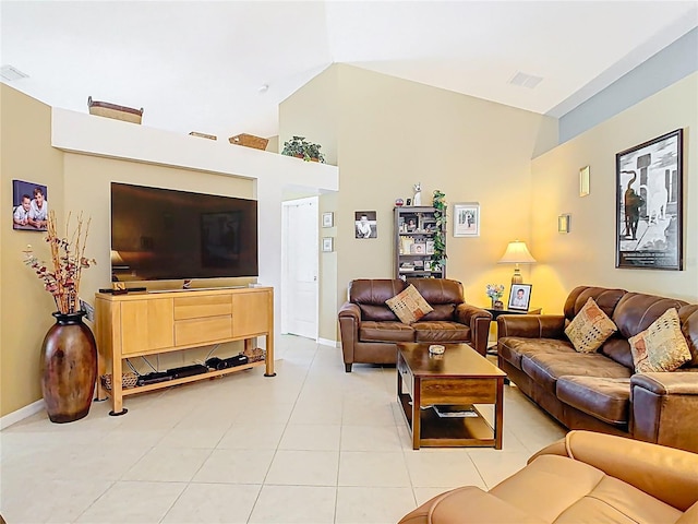 living area with light tile patterned floors, visible vents, baseboards, and high vaulted ceiling