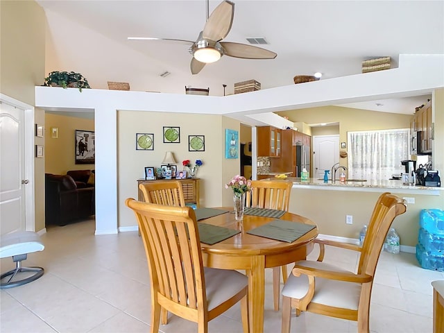 dining space featuring lofted ceiling, light tile patterned floors, visible vents, and ceiling fan