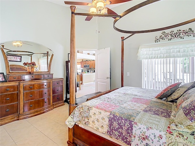 bedroom with light tile patterned floors, a ceiling fan, and a towering ceiling