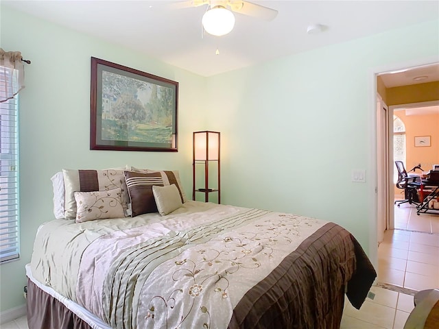 tiled bedroom with a ceiling fan