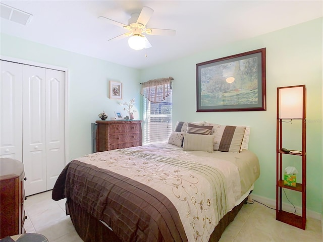 bedroom with visible vents, baseboards, light tile patterned floors, a closet, and a ceiling fan