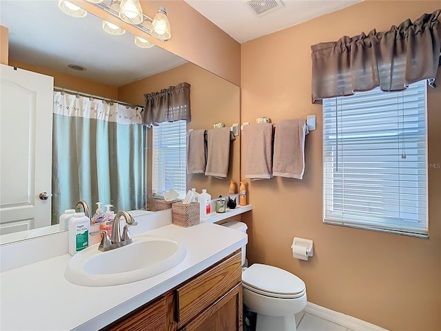 bathroom with visible vents, toilet, a shower with curtain, baseboards, and vanity