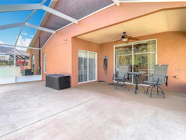 view of patio / terrace with glass enclosure, cooling unit, and a ceiling fan