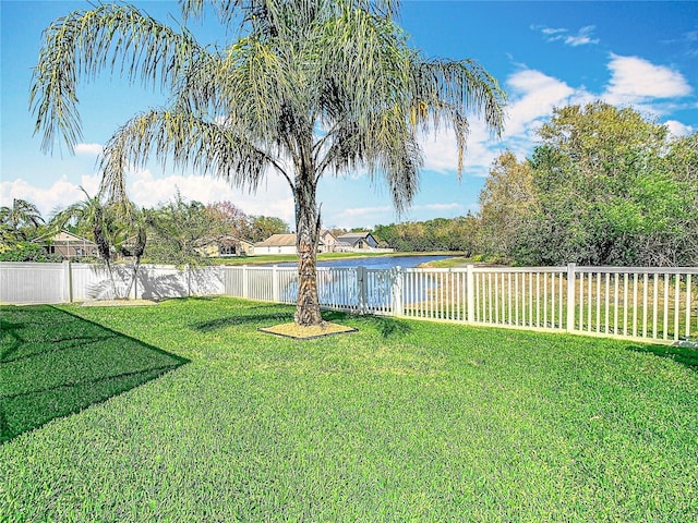 view of yard with a fenced backyard and a water view