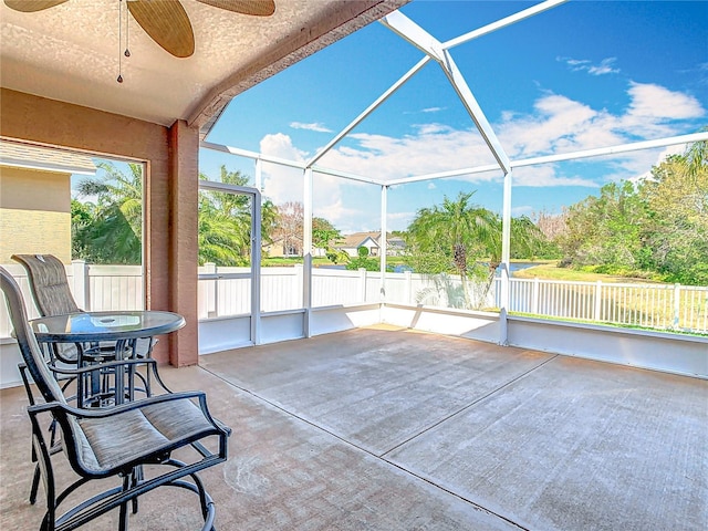 unfurnished sunroom with ceiling fan