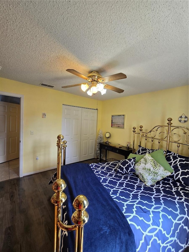 bedroom with wood finished floors, baseboards, visible vents, ceiling fan, and a closet