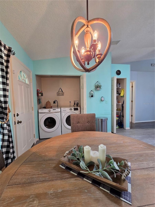 dining space with washer and clothes dryer, a textured ceiling, an inviting chandelier, and wood finished floors