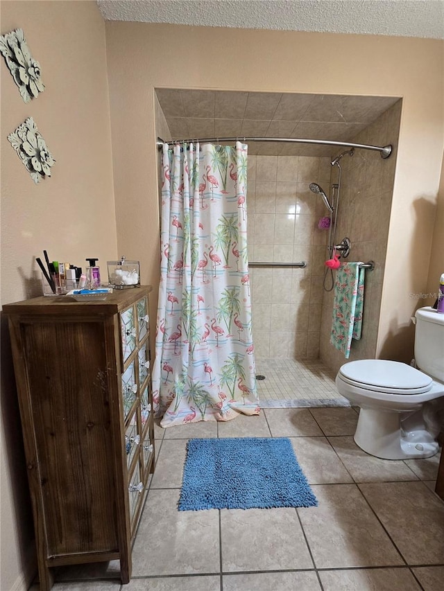 full bath featuring tile patterned floors, tiled shower, and toilet