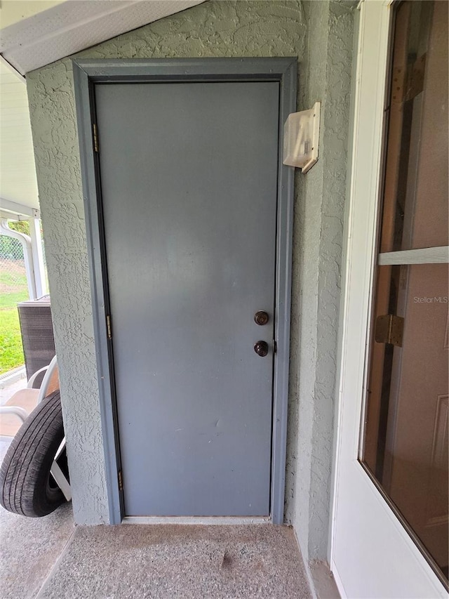 view of exterior entry featuring stucco siding