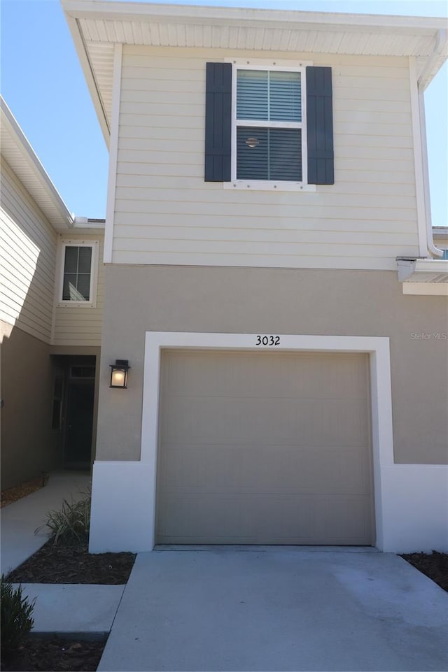 view of front of house featuring an attached garage, driveway, and stucco siding