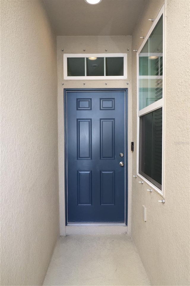 view of exterior entry featuring stucco siding