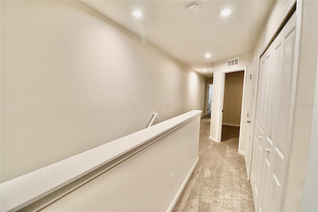 corridor with visible vents, recessed lighting, an upstairs landing, and light colored carpet