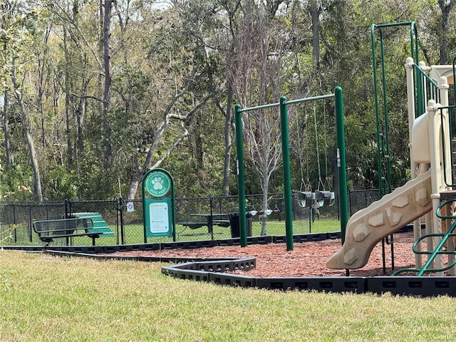 community playground featuring a yard and fence