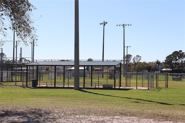 view of property's community featuring a lawn and fence