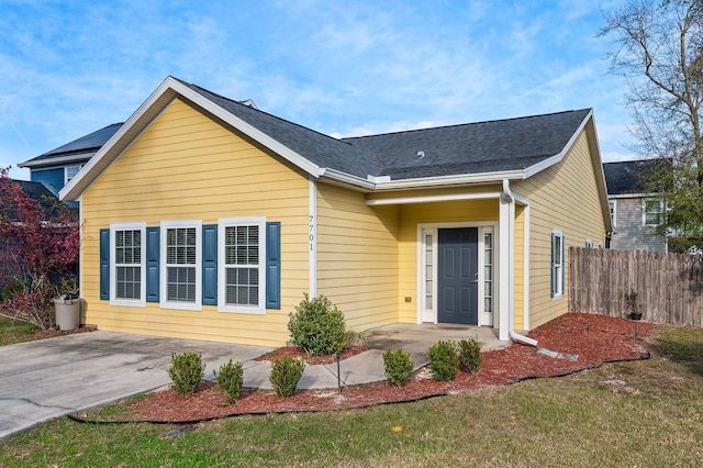 view of front of house featuring fence and a shingled roof