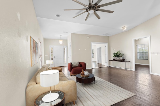 living area featuring visible vents, wood finished floors, baseboards, and ceiling fan