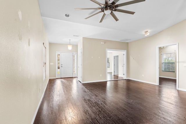 unfurnished living room with a ceiling fan, lofted ceiling, wood finished floors, and baseboards