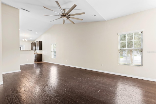 unfurnished living room featuring visible vents, dark wood-type flooring, ceiling fan with notable chandelier, baseboards, and lofted ceiling