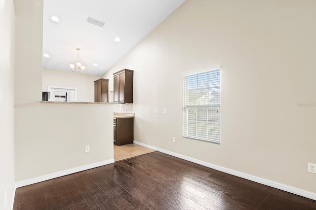 unfurnished living room featuring wood finished floors, baseboards, visible vents, an inviting chandelier, and recessed lighting