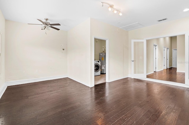 empty room with visible vents, washer / dryer, baseboards, and wood finished floors