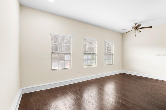 unfurnished room featuring dark wood finished floors, ceiling fan, and baseboards