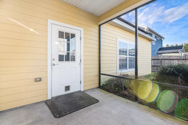 doorway to property featuring fence