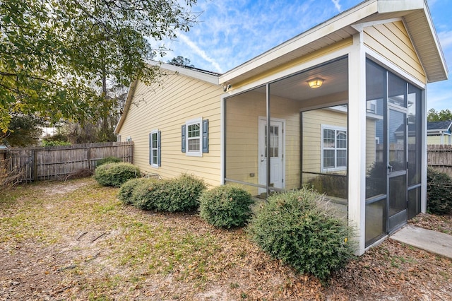 exterior space featuring fence and a sunroom