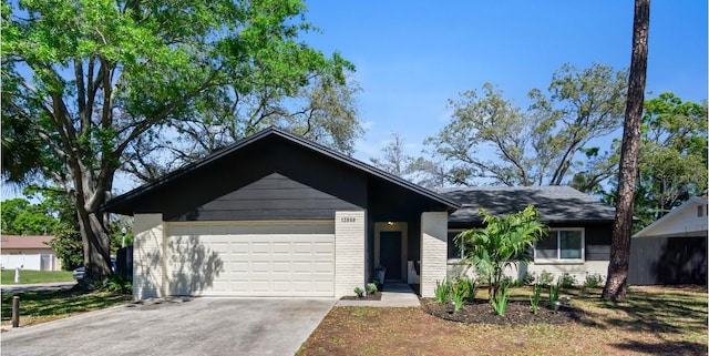 ranch-style home with a garage, concrete driveway, and brick siding