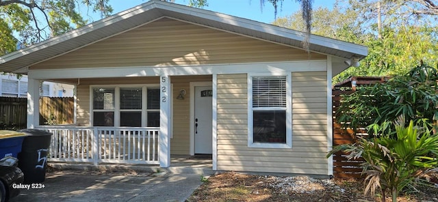 view of front of property featuring a porch and fence