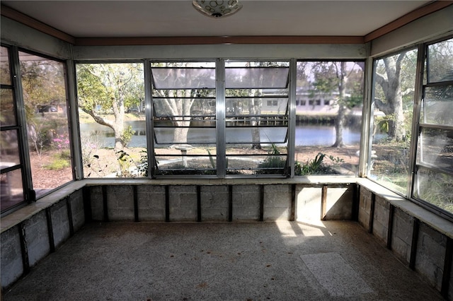 unfurnished sunroom featuring a water view