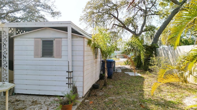 view of side of property with an outbuilding, a shed, and fence